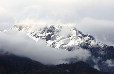 Low angle view of snowcapped mountains against sky
