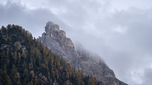 Mountain peak shrouded in fog during autumn season, italy, europe