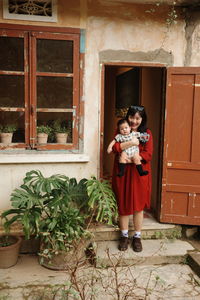 Woman in red ress with her baby