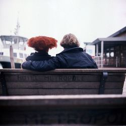 Rear view of woman standing against white wall