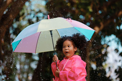 Cute girl holding umbrella outdoors