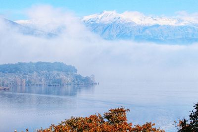 Scenic view of sea by mountains against sky