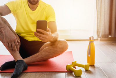 Midsection of man using mobile phone