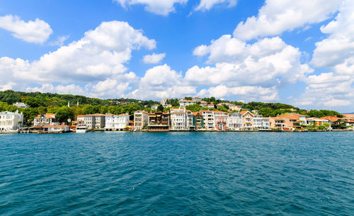 View of town by sea against sky