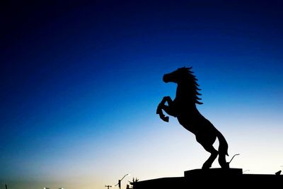 Silhouette of statue against sunset