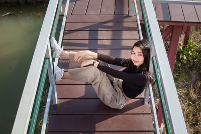 High angle portrait of girl sitting on jetty