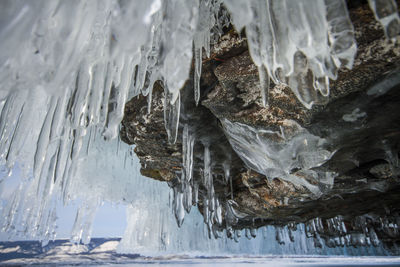 Close-up of icicles on rock at sea during winter