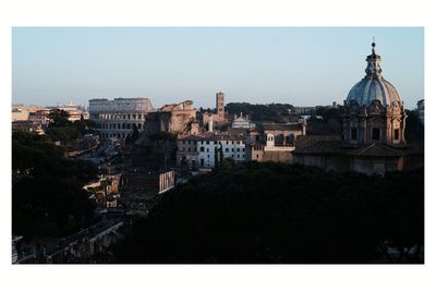 Buildings in city against clear sky