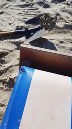 Close-up of man relaxing on sand at beach