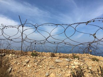 Barbed wire fence against sky