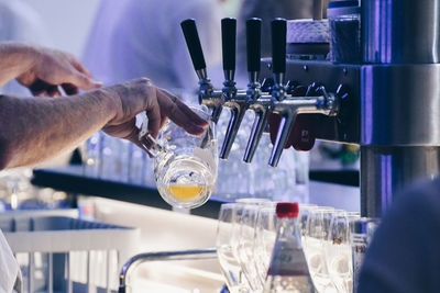 Cropped hands filling glass in restaurant