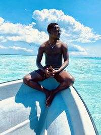 Rear view of shirtless man swimming in sea