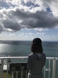 Rear view of woman looking at sea against sky