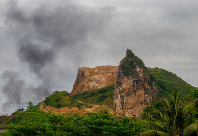 Low angle view of rocks on mountain against sky