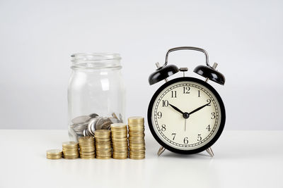 Close-up of clock on table against white background