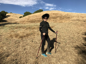 Portrait of young woman wearing sunglasses standing on grassy field at garin regional park
