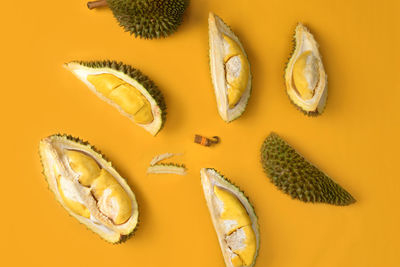 High angle view of lemon and orange on yellow background