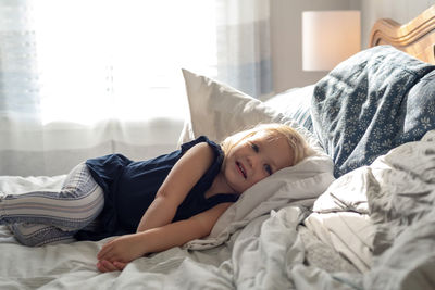 Portrait of girl lying on bed at home