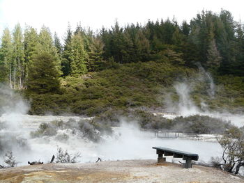 Walkway amidst geysers against sky