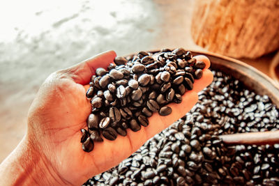 Close-up of hand holding coffee beans