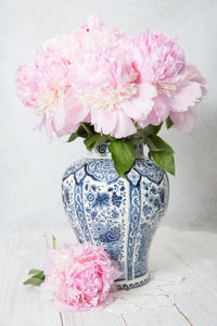 Pink luxurious peonies in an ancient chinese vase with blue ornament, springtime