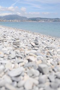 Surface level of stones on beach against sky