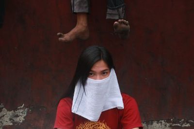 Young woman standing against wall