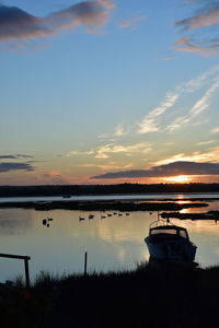 Scenic view of harbour against sky during sunrise 