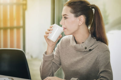 Young woman drinking coffee cup