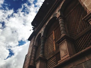 Low angle view of historic building against cloudy sky