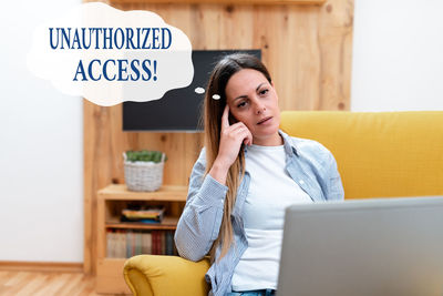 Young woman using mobile phone at home