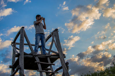 Low angle view of woman standing against sky