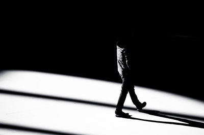 Low section of person standing against black background