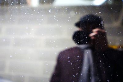 Reflection of person on wet glass