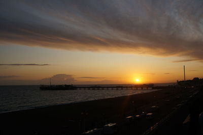 Scenic view of sea against dramatic sky during sunset