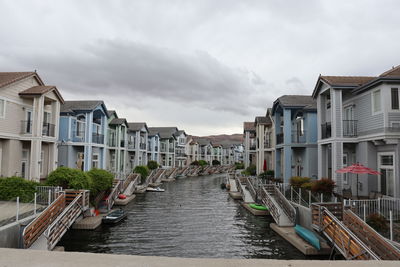 Canal amidst buildings against sky