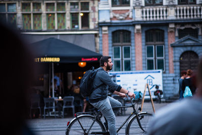 Side view of man riding bicycle on street