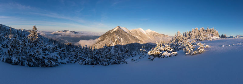 Scenic view of snowcapped mountains against blue sky