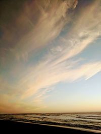 Scenic view of sea against dramatic sky during sunset