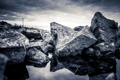 Close-up of snow on rock against sky