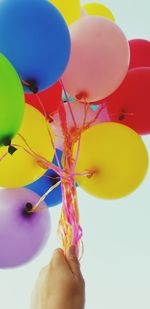 Close-up of hand holding balloons