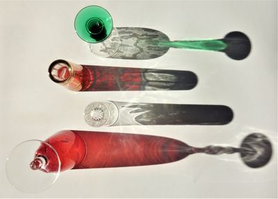 High angle view of hand holding glass over white background