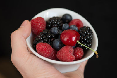 Close-up of hand holding strawberries