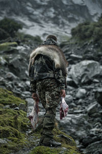 Hunter in mountains carrying meat