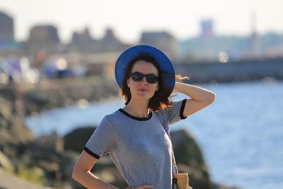 Portrait of young woman wearing sunglasses standing outdoors