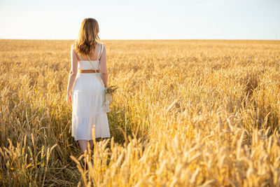 Rear view of woman standing in field