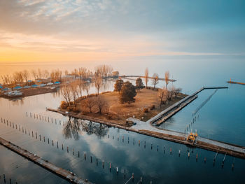 High angle view of trees by lake against sky during sunset