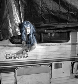 Portrait of girl with dyed hair looking through vehicle window