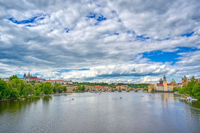 River by buildings in city against sky