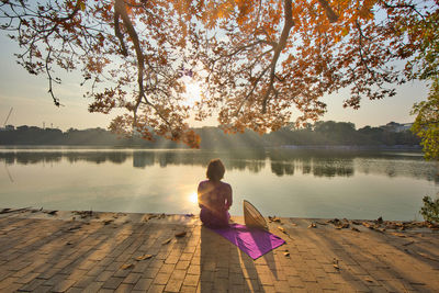 Beauty vietnamese woman wearing ao dai dress at hoan kiem lake in sunset.